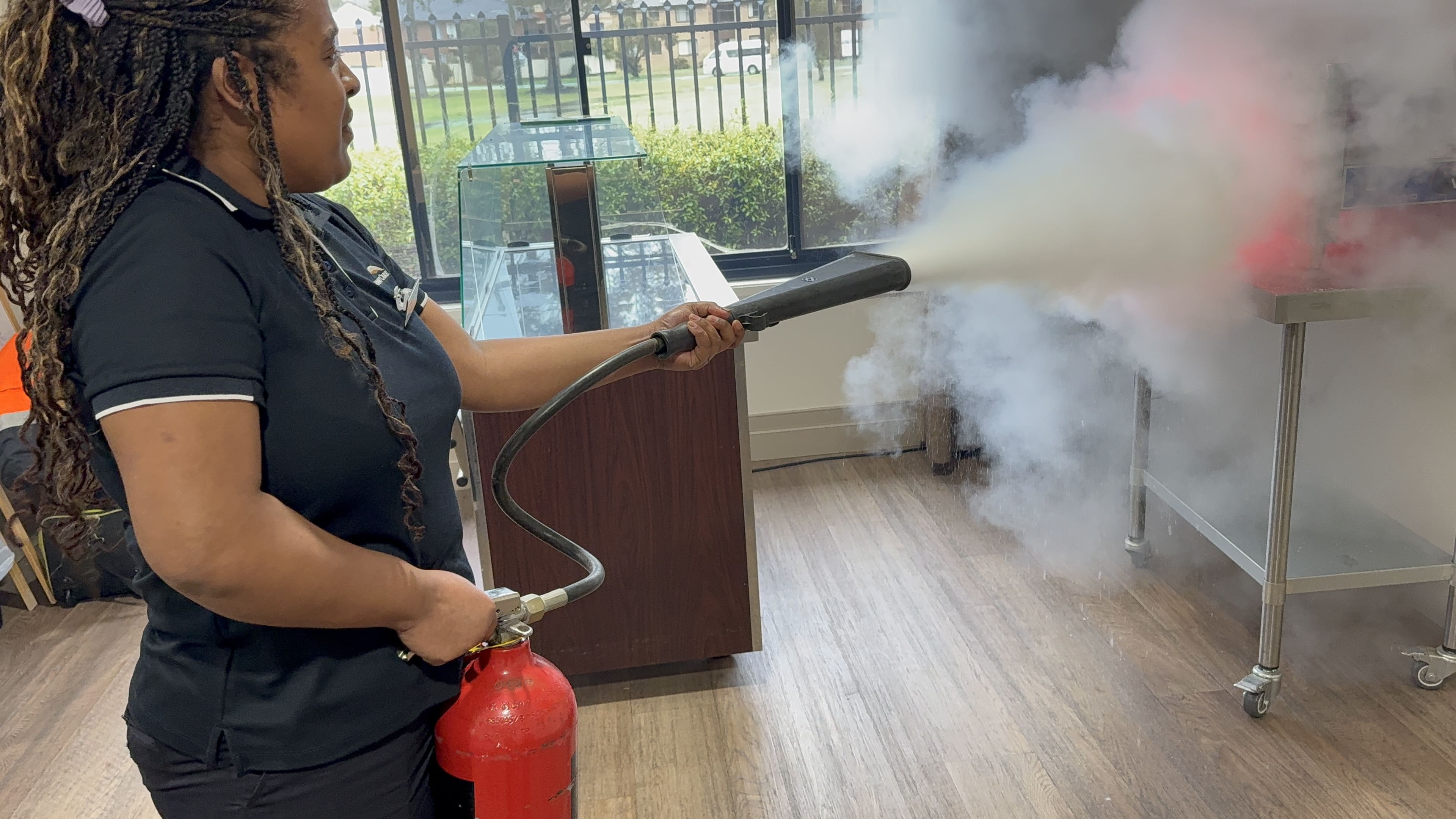 Staff member using a fire extinguisher during hands-on fire training