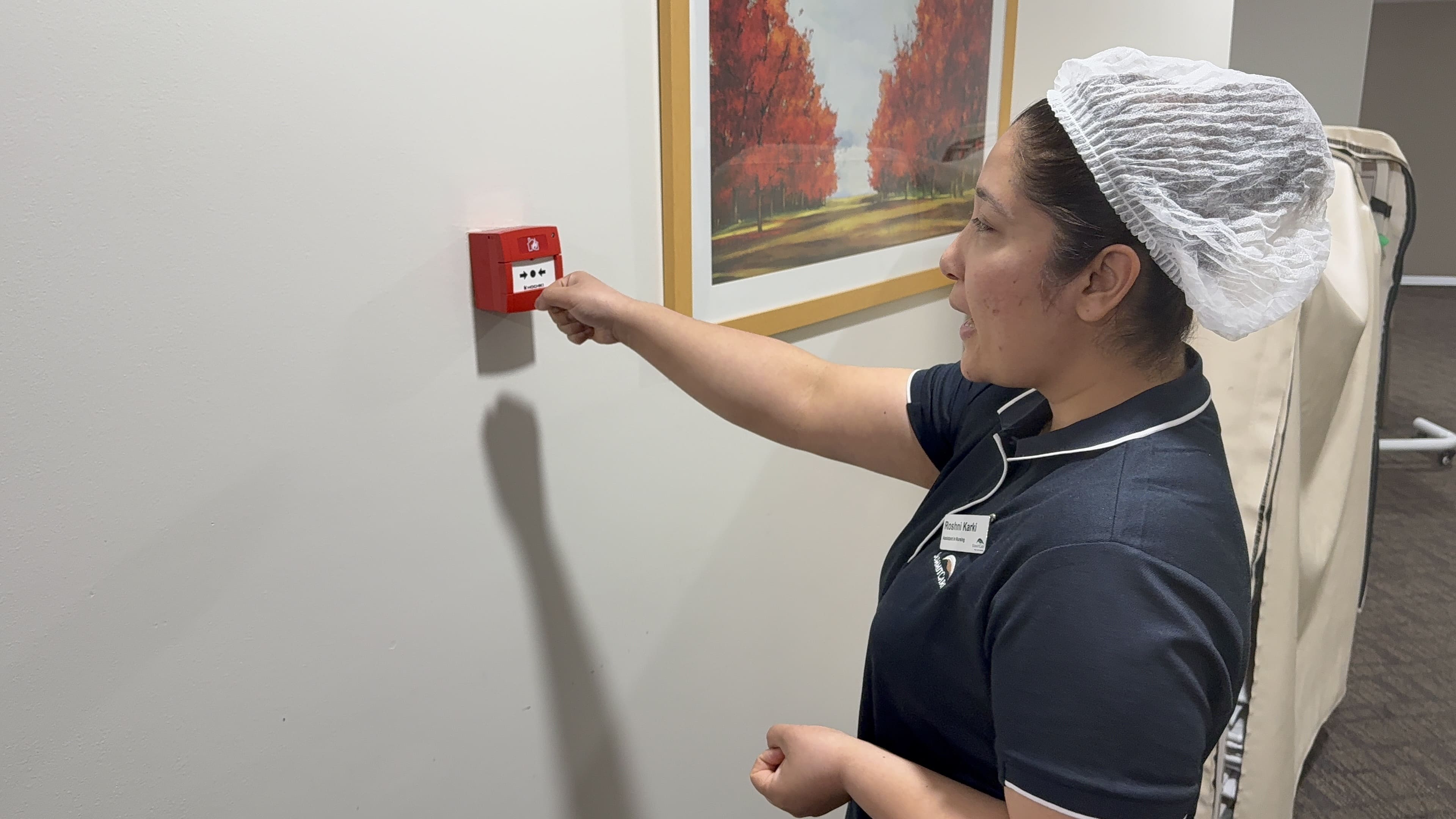 Staff member activating a manual fire alarm call point