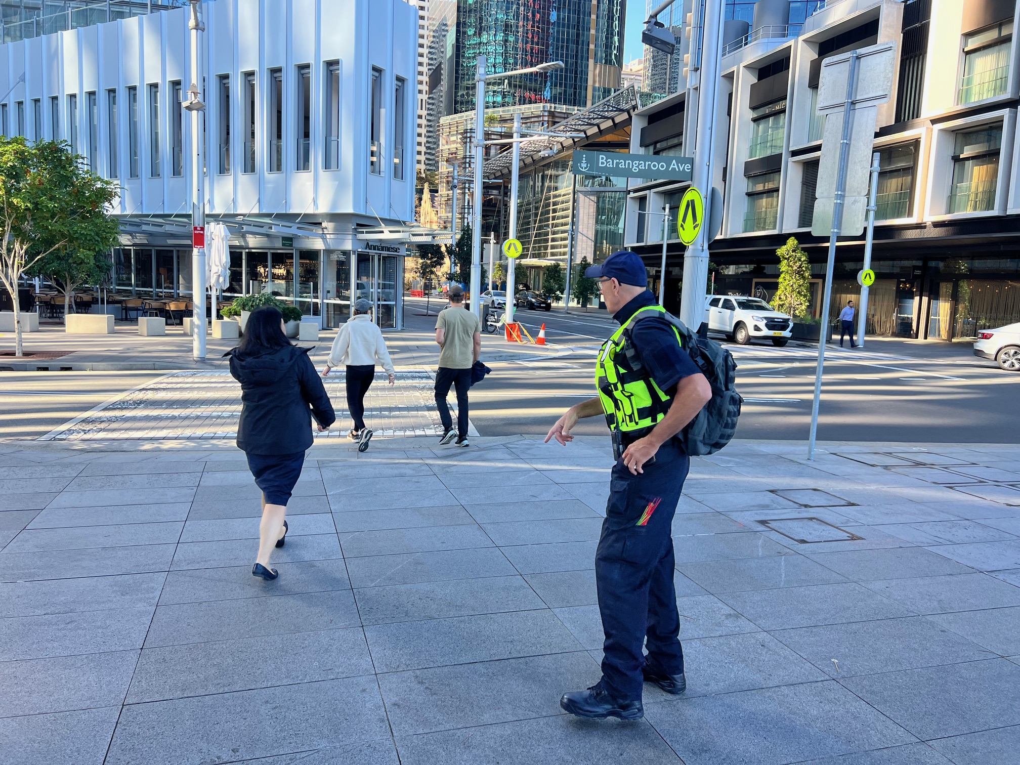 Security officer directing pedestrians outside office towers